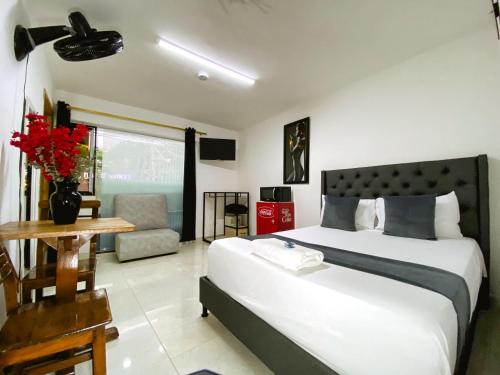 a bedroom with a large bed and a living room at Hotel Lleras # 1 in Medellín