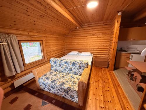 a small room with a bed and a chair in it at Kolmiloukon leirintämökit in Taivalkoski