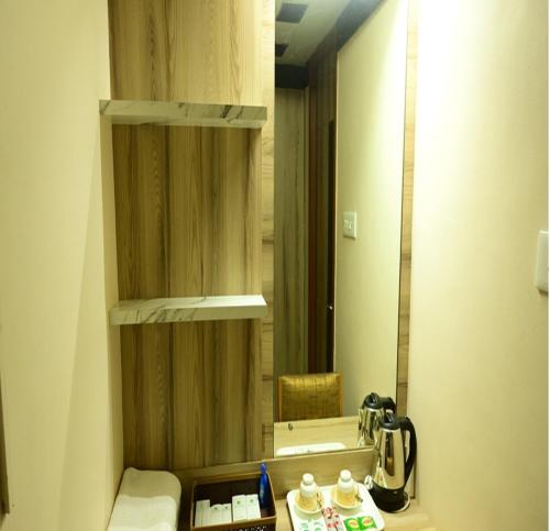 a bathroom with a sink and a mirror in a room at Hotel PAMS in Mayiladuthurai