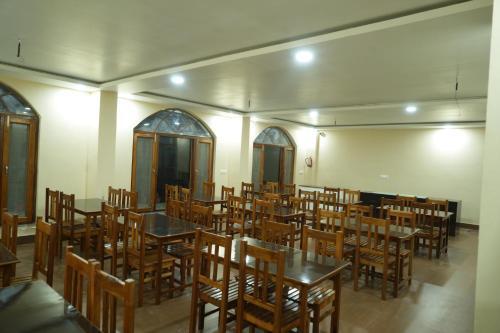 a dining room with tables and chairs in it at The Kalindi's Resort, Almora in Almora