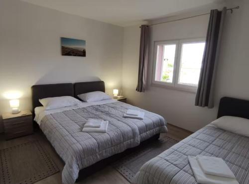 a bedroom with two beds and a window at Apartment Serenity in Rogotin