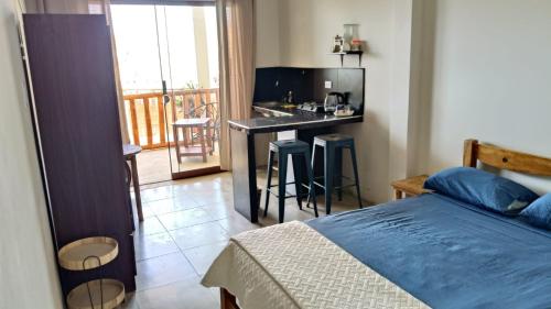 a bedroom with a bed and a kitchen with a balcony at Loft5 matrimonial Playa Pocitas in Máncora