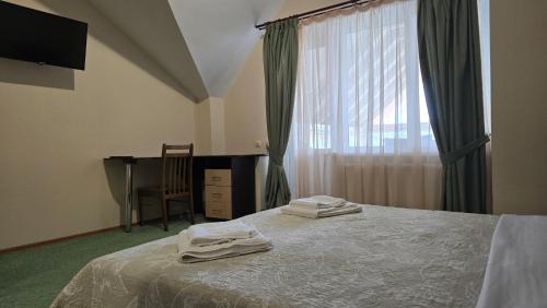 ein Schlafzimmer mit Bett, Fenster und Schreibtisch in der Unterkunft Grace Villa in Codru