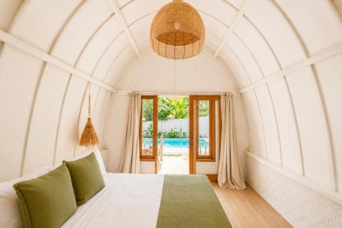 a bedroom with a bed and a large window at Kelapa Lodge - Lombok - in Senggigi
