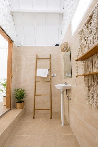 a bathroom with a sink and a towel ladder at Kelapa Lodge - Lombok - in Senggigi