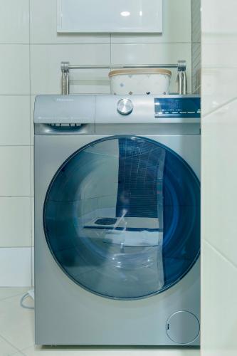 a white washing machine in a white kitchen at Naia Residence - 2BR Oceanview in Dar es Salaam