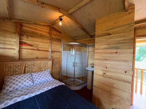 a bedroom with a shower in a wooden cabin at Mi Refugio Mamre in Tlazala de Fabela