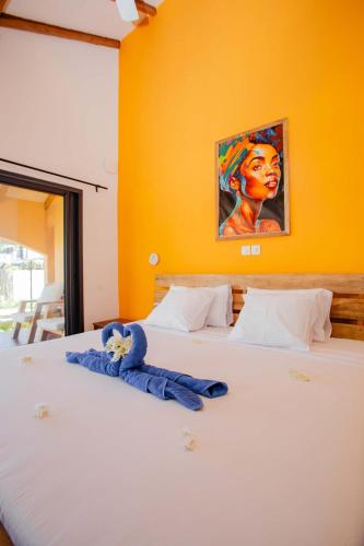 a bed with a stuffed animal on top of it at Résidence Swiss Nosy be in Nosy Be