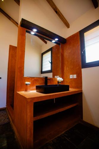 a bathroom with a sink and a mirror at Résidence Swiss Nosy be in Nosy Be
