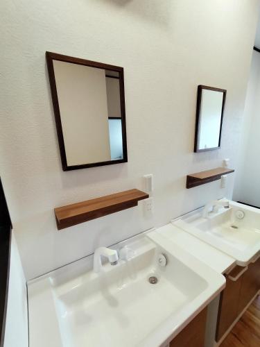 ein weißes Badezimmer mit zwei Waschbecken und einem Spiegel in der Unterkunft Otowa音和 in Kijimadaira