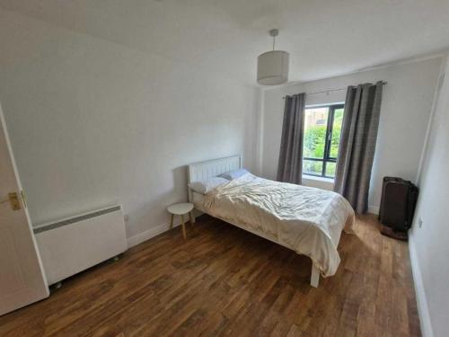 a white bedroom with a bed and a window at Spacious Bright Modern Apt With Garden in Dublin