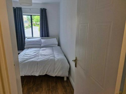 a small bedroom with a bed and a window at Spacious Bright Modern Apt With Garden in Dublin