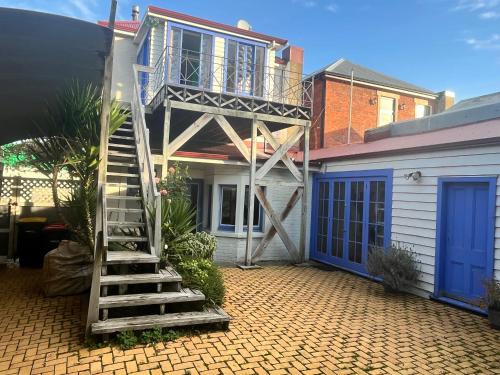 a staircase leading up to a house with a balcony at Inner City Oasis in Invercargill