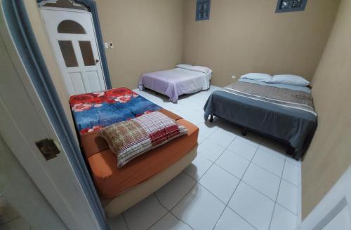 a room with two beds and a mirror at Hostel New Brothers in Panajachel