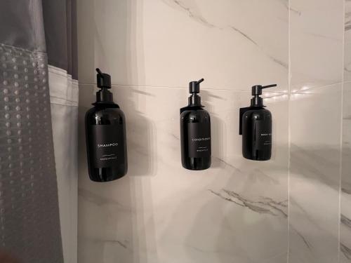 a bathroom with four black bottles on the wall at Greystone Ranch Pet Friendly in Clarksville
