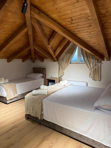 two beds in a room with wooden ceilings at Grand Station Hotel in Shkodër