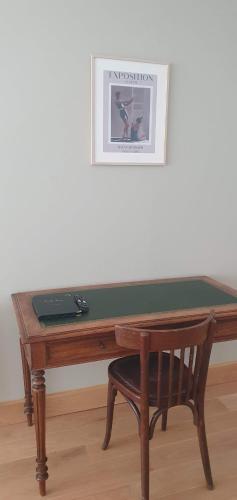 a wooden desk with a chair and a picture on the wall at Les Cabines in Houlgate