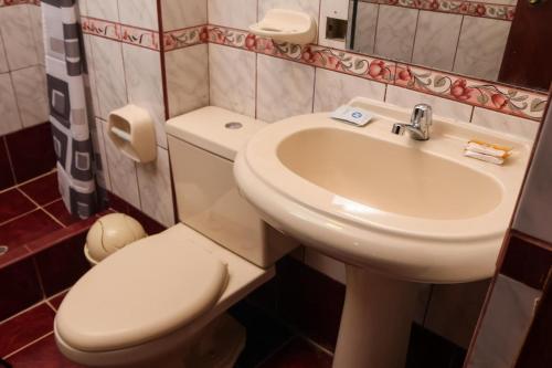 a bathroom with a white toilet and a sink at Apachetas Hotel in Machu Picchu