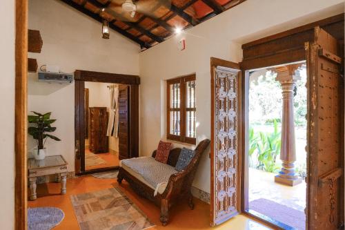 a living room with a chair and a mirror at White Serenity Heritage Pool Villa near Beach Udupi in Udupi