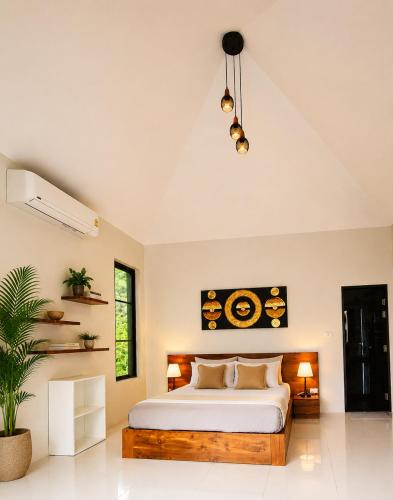 a bedroom with a large bed and a potted plant at Mirari Villa in Wok Tum