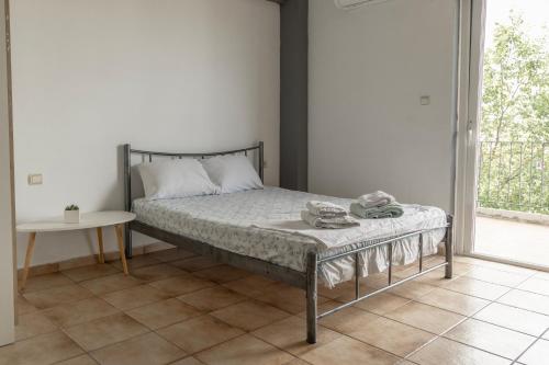 a bedroom with a bed and a table and a window at Elia mini suite 2 in Larisa