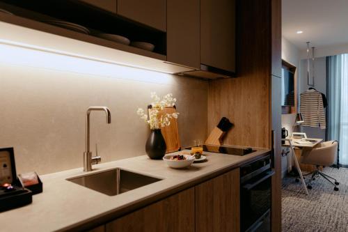 a kitchen with a sink and a vase of flowers on the counter at Punthill Epping in Epping