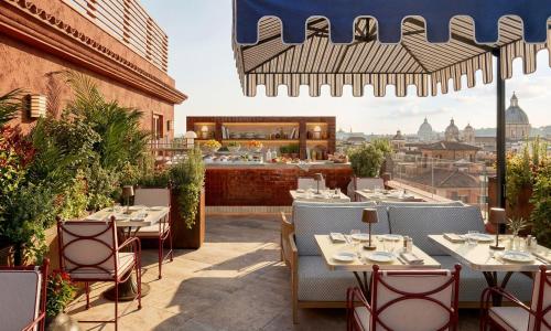 a restaurant with tables and chairs and a view of the city at Thompson Rome, By Hyatt in Rome