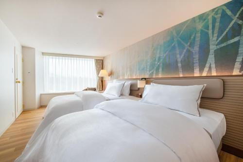 a row of white beds in a hotel room at The Westin Rusutsu Resort in Rusutsu