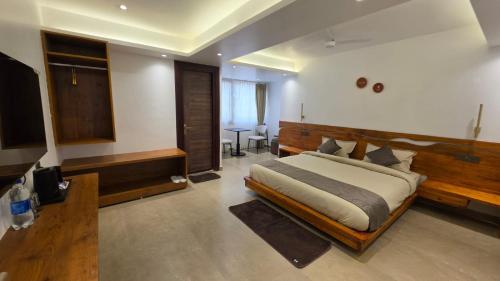 a bedroom with a large bed and a television at Hotel Anukampa in Rāmgarh