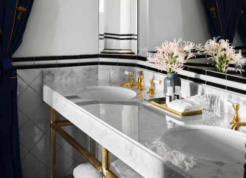 two sinks in a bathroom with a marble counter at The Georgian, in The Unbound Collection by Hyatt in Santa Monica
