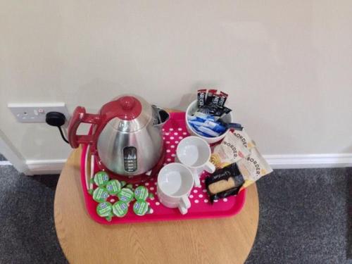 a pink tray with a tea pot on a table at Airport Tavern Accommodation in Felton