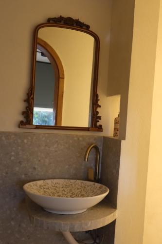 a sink in a bathroom with a mirror at A Lómbre in Ḩarīq al Kufūr