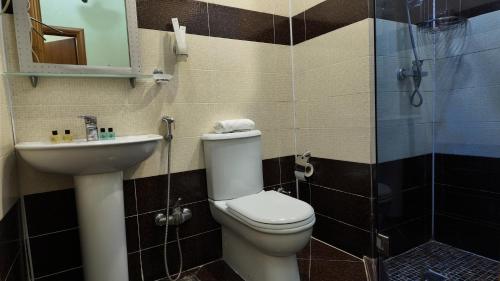 a bathroom with a toilet and a sink and a shower at Porto Bistro in Baku
