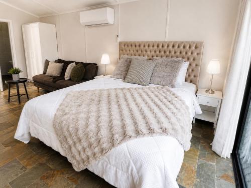 a bedroom with a large bed and a couch at Coastal Studio in Seacliff