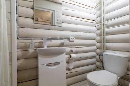 a bathroom with a toilet and a wooden wall at Fiesta in Solotvyno