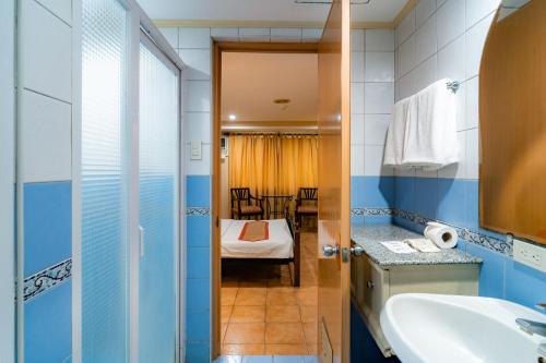 a bathroom with a sink and a bedroom at Crown Regency Residences Davao in Davao City