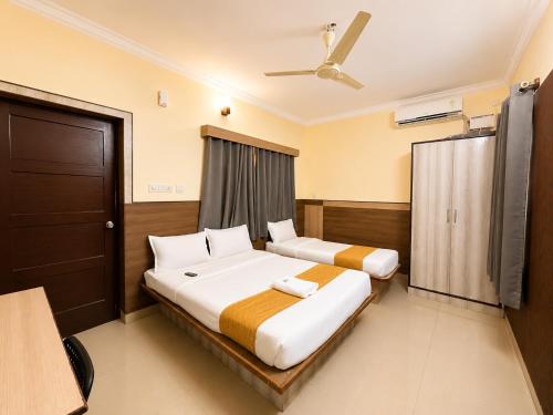 a hotel room with two beds and a window at HOTEL Nh MAJESTIC in Bangalore