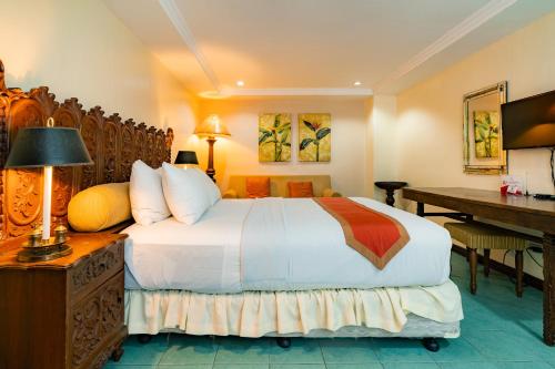 a hotel room with a bed and a desk and a desk at Crown Regency Residences Davao in Davao City