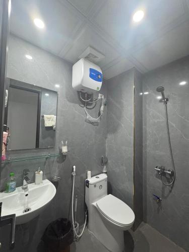 a bathroom with a toilet and a sink at Rochomes Apartment in Thịnh Châu
