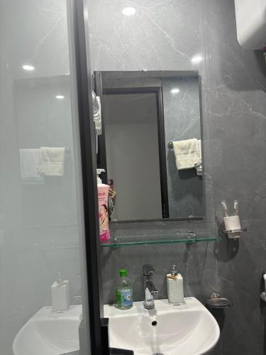 a bathroom with a sink and a mirror at Rochomes Apartment in Thịnh Châu