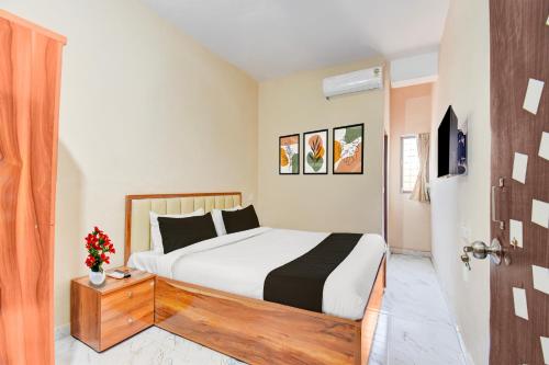 a bedroom with a bed and a door open at Super Hotel O Dehu Pune Formerly Gathaa Inn in Dehu