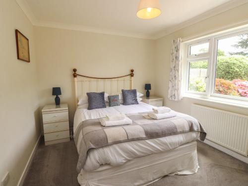 a bedroom with a large bed and a window at Bro Mebyd in Criccieth