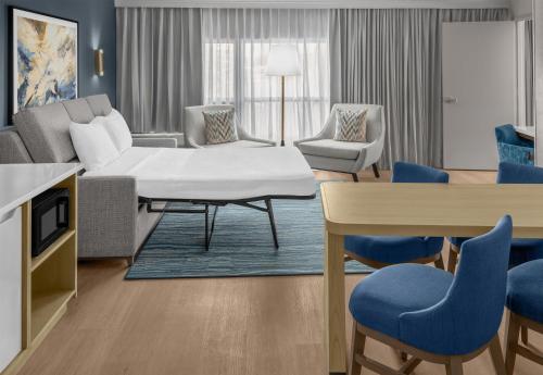 a living room with a couch and a table and chairs at DoubleTree by Hilton Hotel South Bend in South Bend