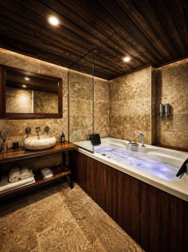 a large bathroom with a tub and a sink at Sakli Cave House in Avanos