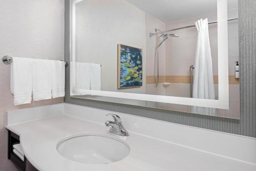 a white bathroom with a sink and a mirror at Hilton Garden Inn Wayne in Wayne