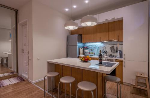 a kitchen with a counter and stools in a room at Hyacinth House in Tbilisi City
