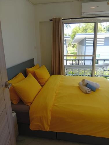 a bedroom with a yellow bed with a teddy bear on it at Stylish 1BR Retreat with Workspace & Hammock in Hinkong