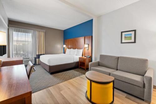 a hotel room with a bed and a couch at Comfort Suites Bethlehem Near Lehigh University and LVI Airport in Bethlehem