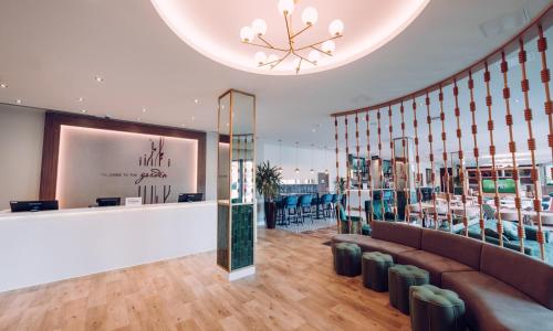a lobby with a waiting area with a couch and chairs at Hilton Garden Inn Manchester Emirates Old Trafford in Manchester