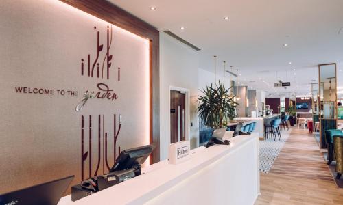 a lobby with a welcome to the office sign on the wall at Hilton Garden Inn Manchester Emirates Old Trafford in Manchester